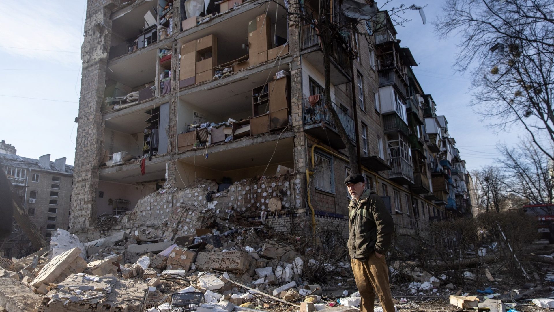 A man stands amid debris in front of a residential apartment complex in Kyiv that was heavily damaged by a Russian attack in March 2022. Photo: Chris McGrath/Getty