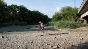 A man searches the bottom of a dried Kakhovka reservoir, after Kakhovka dam explosion in Nikopol, Ukraine. Photo: Amadeusz Swierk/Anadolu Agency via Getty Images