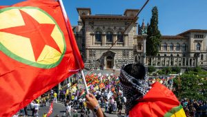 A man waves a flag of Kurdistan Workers' Party next to the Palais de Rumine during a protest to mark the 100th anniversary of the Treaty of Lausanne. Photo: FABRICE COFFRINI/AFP via Getty Images