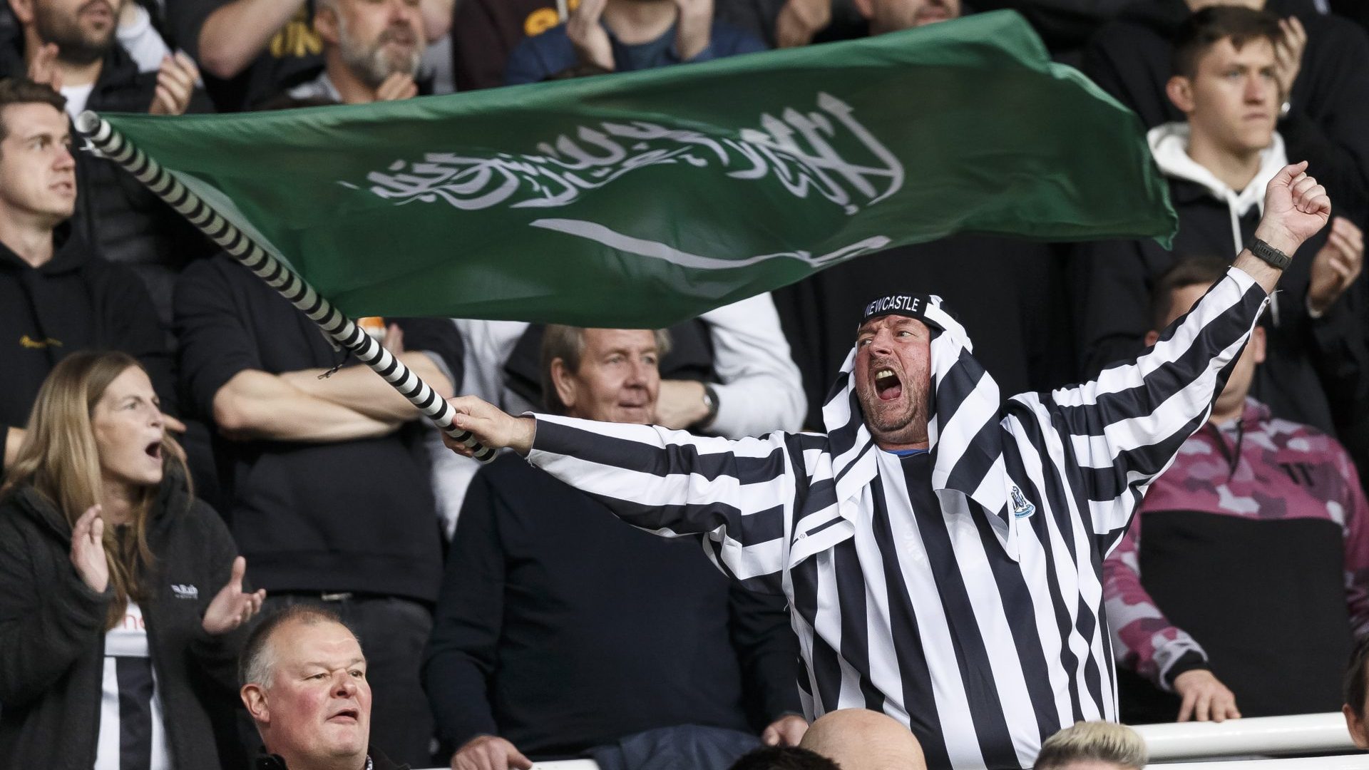 A Newcastle United fan waves a Saudi Arabia flag during his side’s Premier League match against Tottenham, October 2021. Photo: Daniel Chesterton/Offside