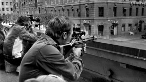 Photographers and police snipers lie side by side on a roof opposite the Kreditbanken in Stockholm, August 24 1973. Photo: Roland Jansson/TT News/AFP/Getty