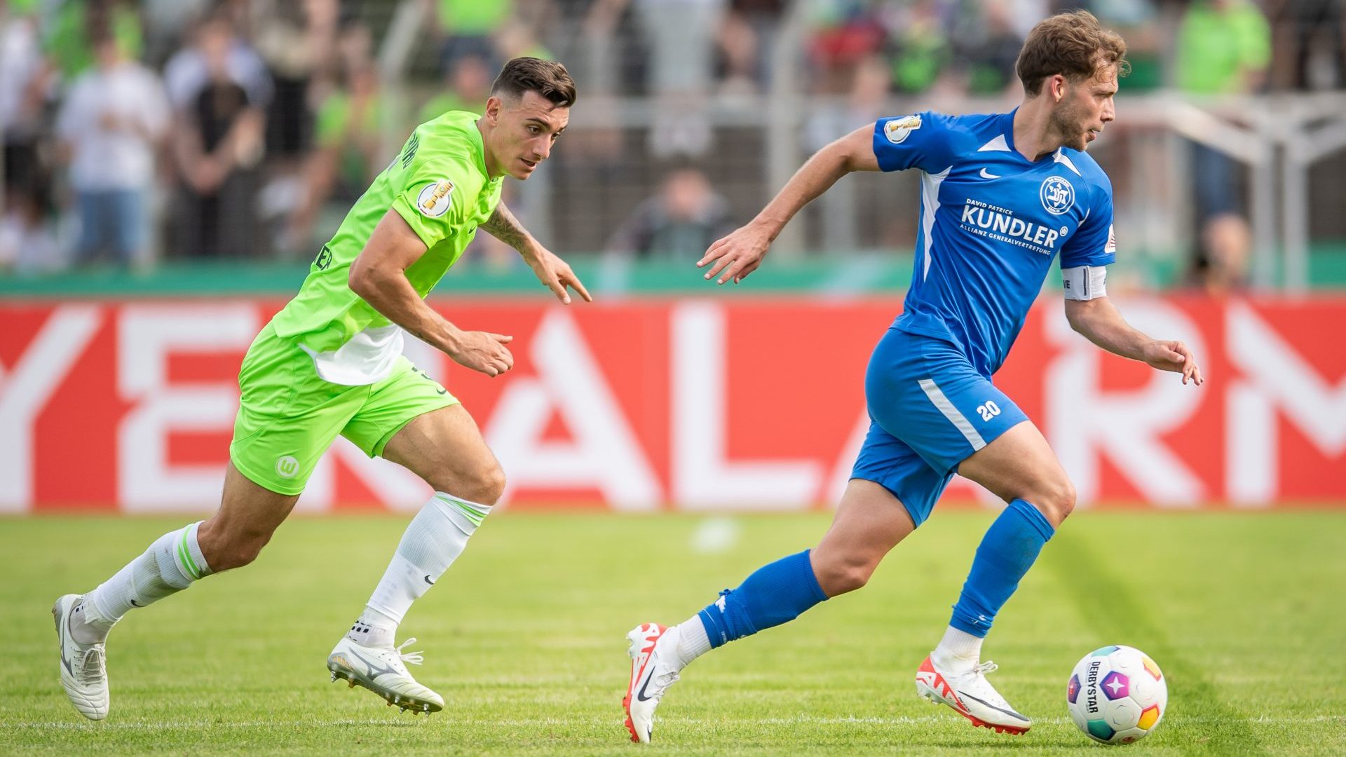 Joakim Maehle Pedersen of VfL Wolfsburg battles for possession with Doron Bruck of TuS Makkabi Berlin during the DFB-Pokal first round match (Photo by Luciano Lima/Getty Images)