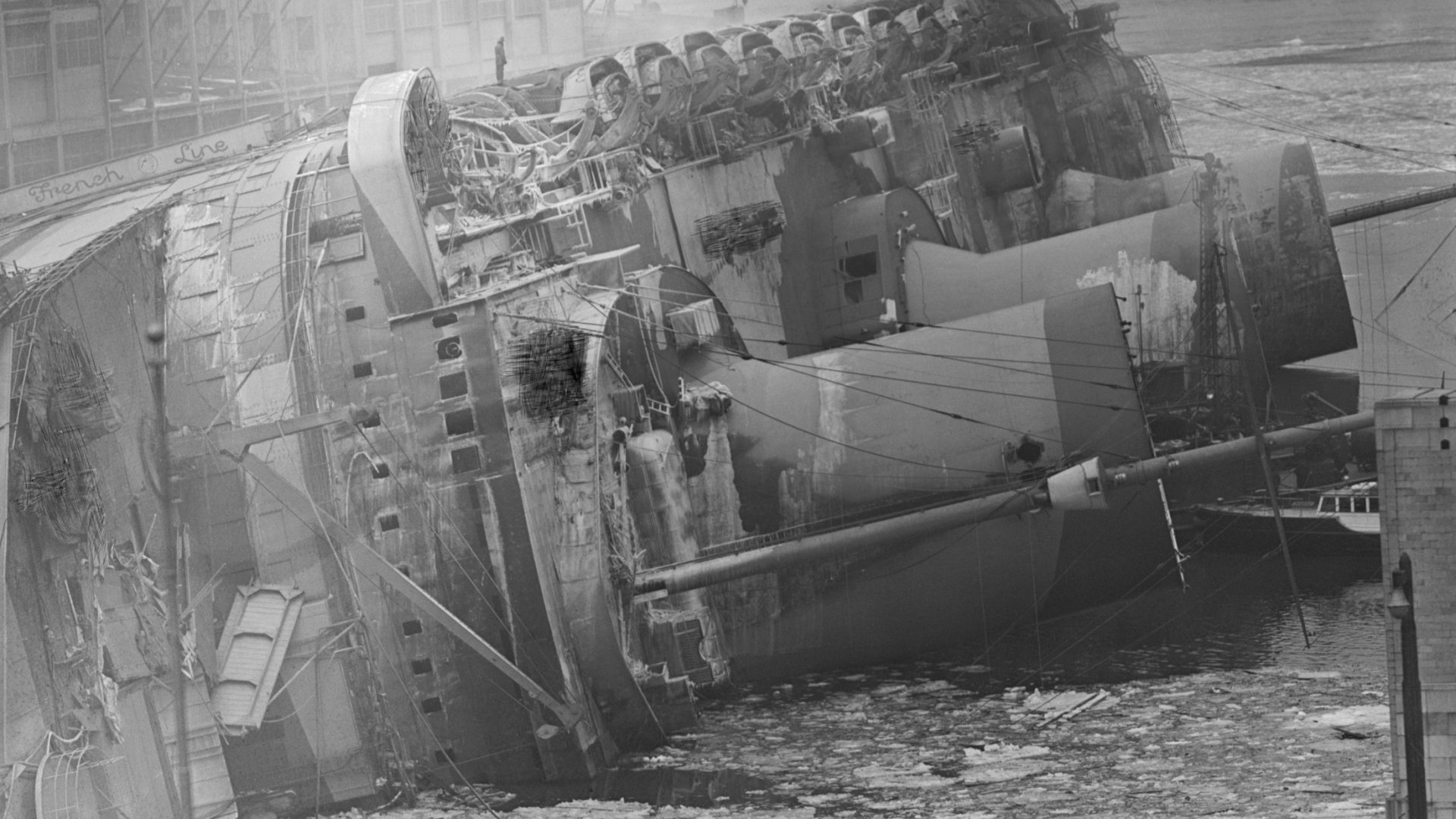 The wreck of the SS Normandie (renamed the USS Lafayette) lies on its side in the Hudson River, New York City, after it was destroyed in a catastrophic fire on February 9, 1942. Photo: Bettmann/Getty
