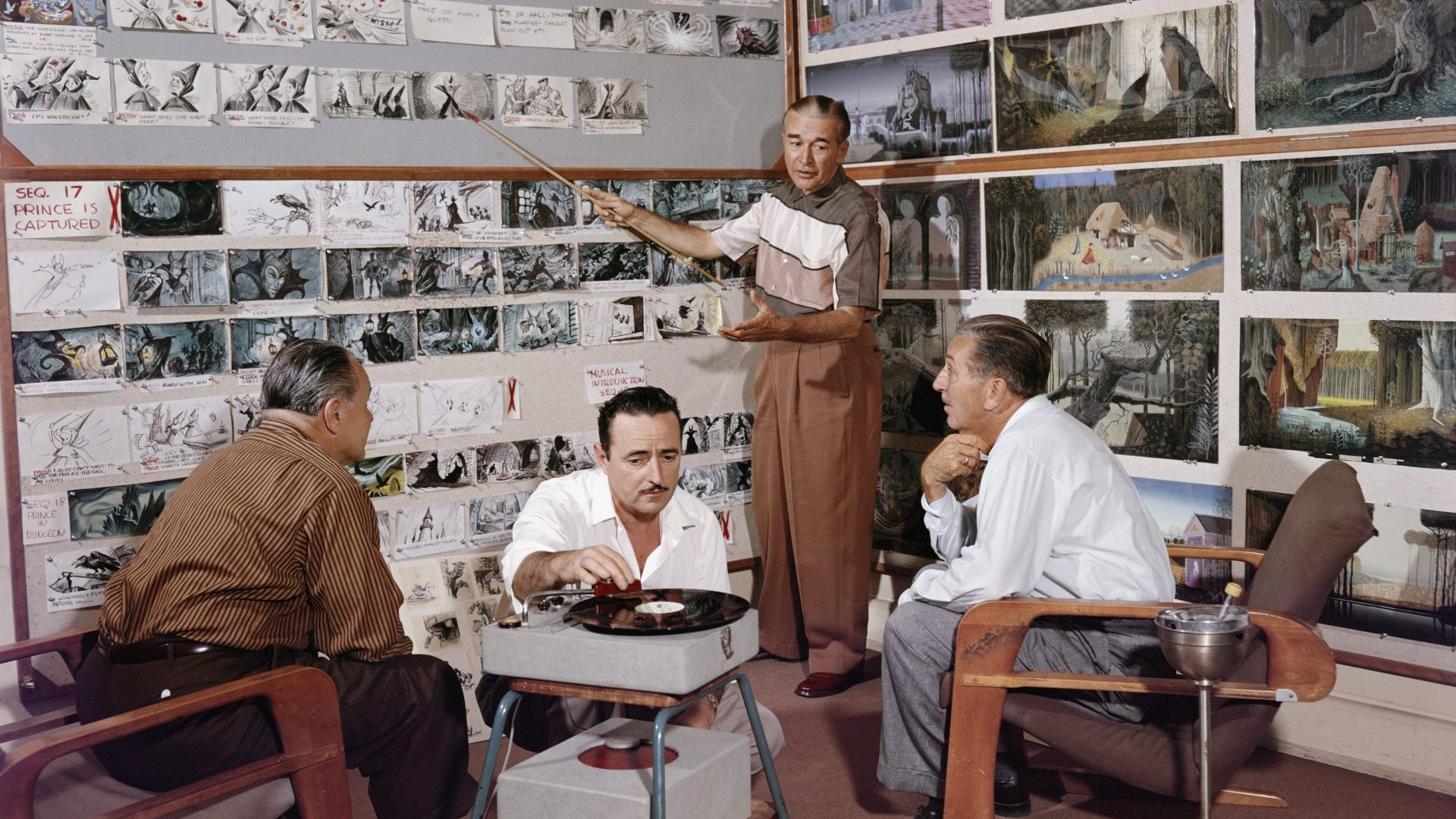 California, 1950s: Walt Disney (right) listens to an animator talk through the storyboards for the 1959 film Sleeping Beauty. Beside them, animator Les Clark plays a record while a fourth man listens. Photo: Gene Lester/Getty