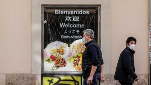 Two people walk past a shop in Valencia's Chinatown on Pelayo Street. Photo:  Rober Solsona/Europa Press via Getty Images
