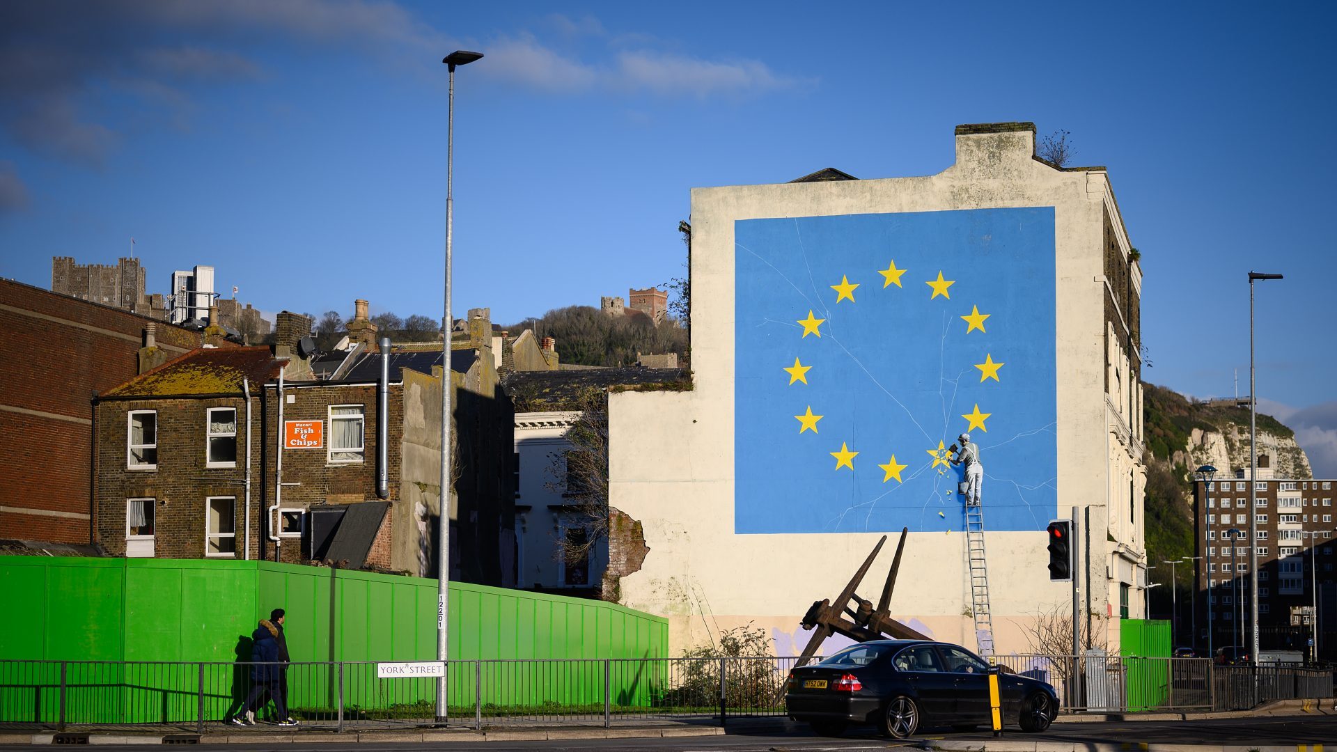 A painting depicting a workman chipping away at a star on the EU flag by artist Banksy. Photo: Leon Neal/Getty Images