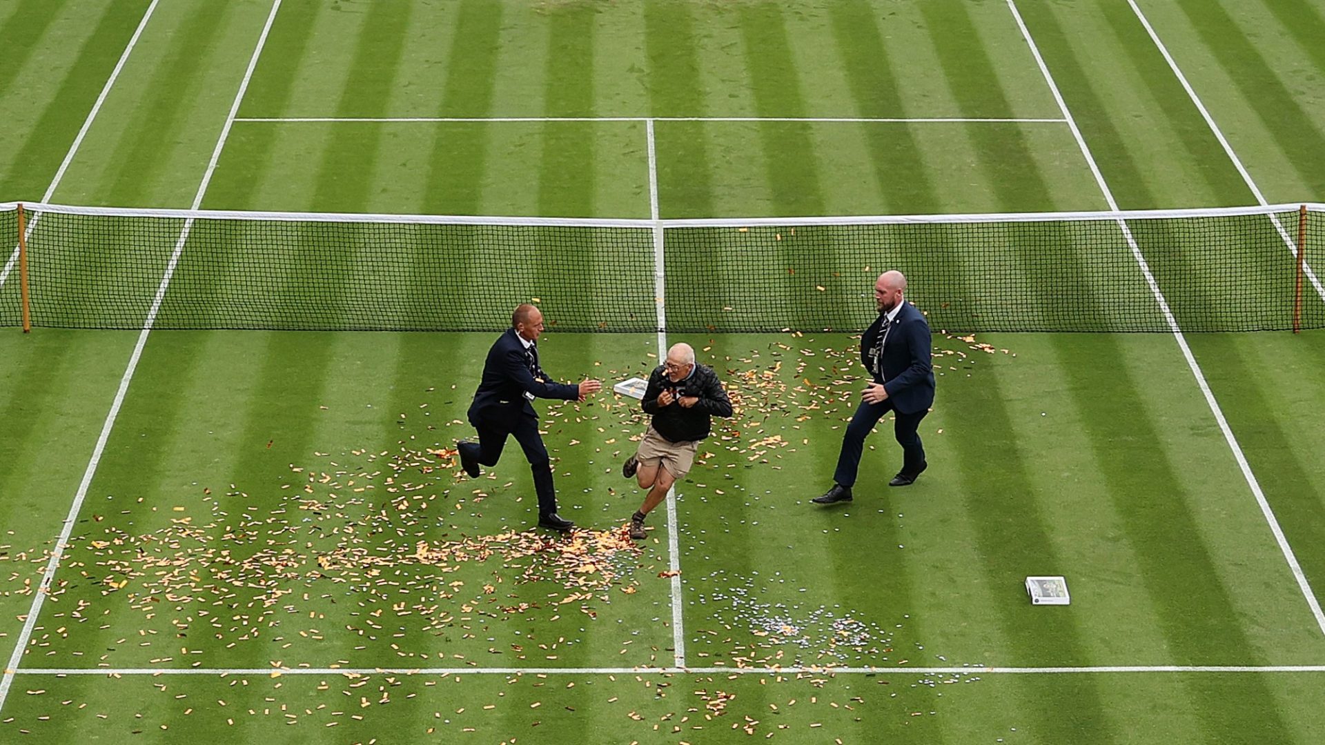 A JSO protester is challenged by security on court 18 at Wimbledon in London, 2023. Photo: Julian Finney/Getty