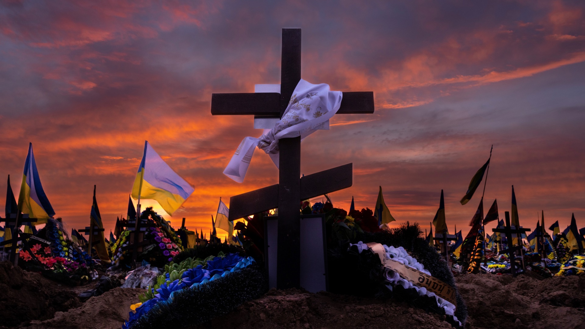 A colourful sunset over military graves in Kharkiv cemetery, Ukraine, in March. The military section of this large graveyard is almost full as many soldiers fighting in the war come from the city. Photo: Paula Bronstein /Getty