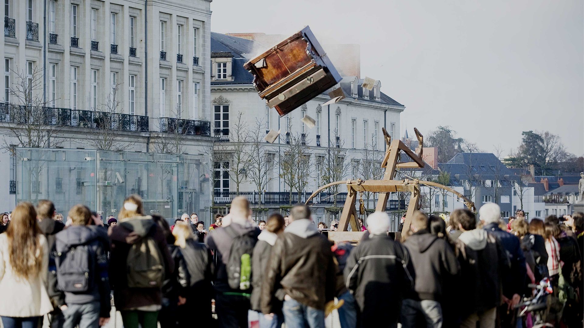 Members of the public look at a piano throw with a catapult during a Royal de Luxe street theatre performance in Nantes. Photo: JEAN-SEBASTIEN EVRARD/AFP via Getty Images