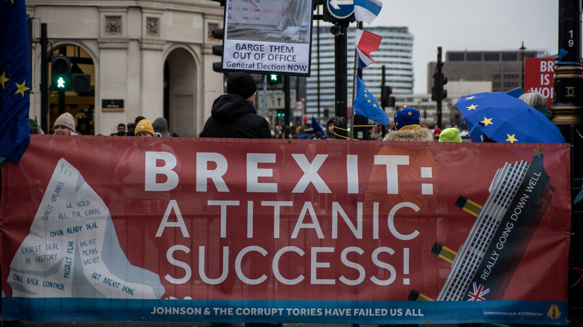 A protester holds a placard with an image of the Bibby Stockholm behind an anti Brexit banner (Photo by Krisztian Elek/SOPA Images/LightRocket via Getty Images)