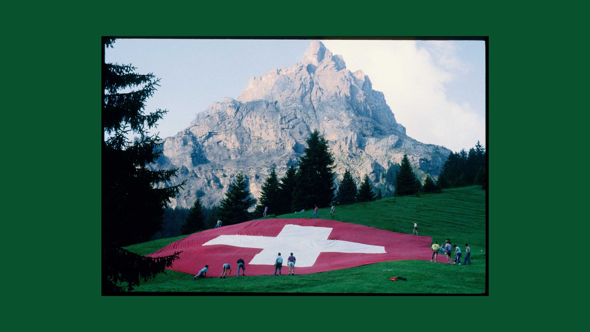 People laying Swiss flag on alp, National Holiday 1991. Photo: Blick/RDB/ullstein bild via Getty Images)
