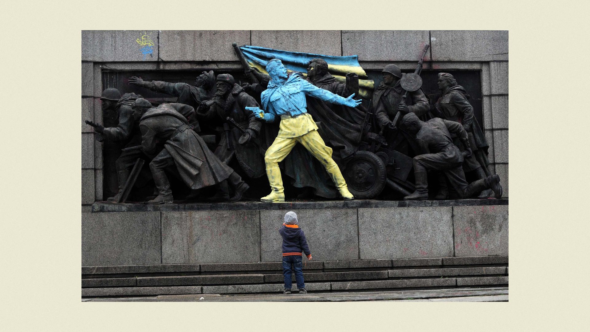 A boy looks at a figure painted in the colours of Ukraine on the monument of the Soviet Army in central Sofia. Photo: NIKOLAY DOYCHINOV/AFP via Getty Images