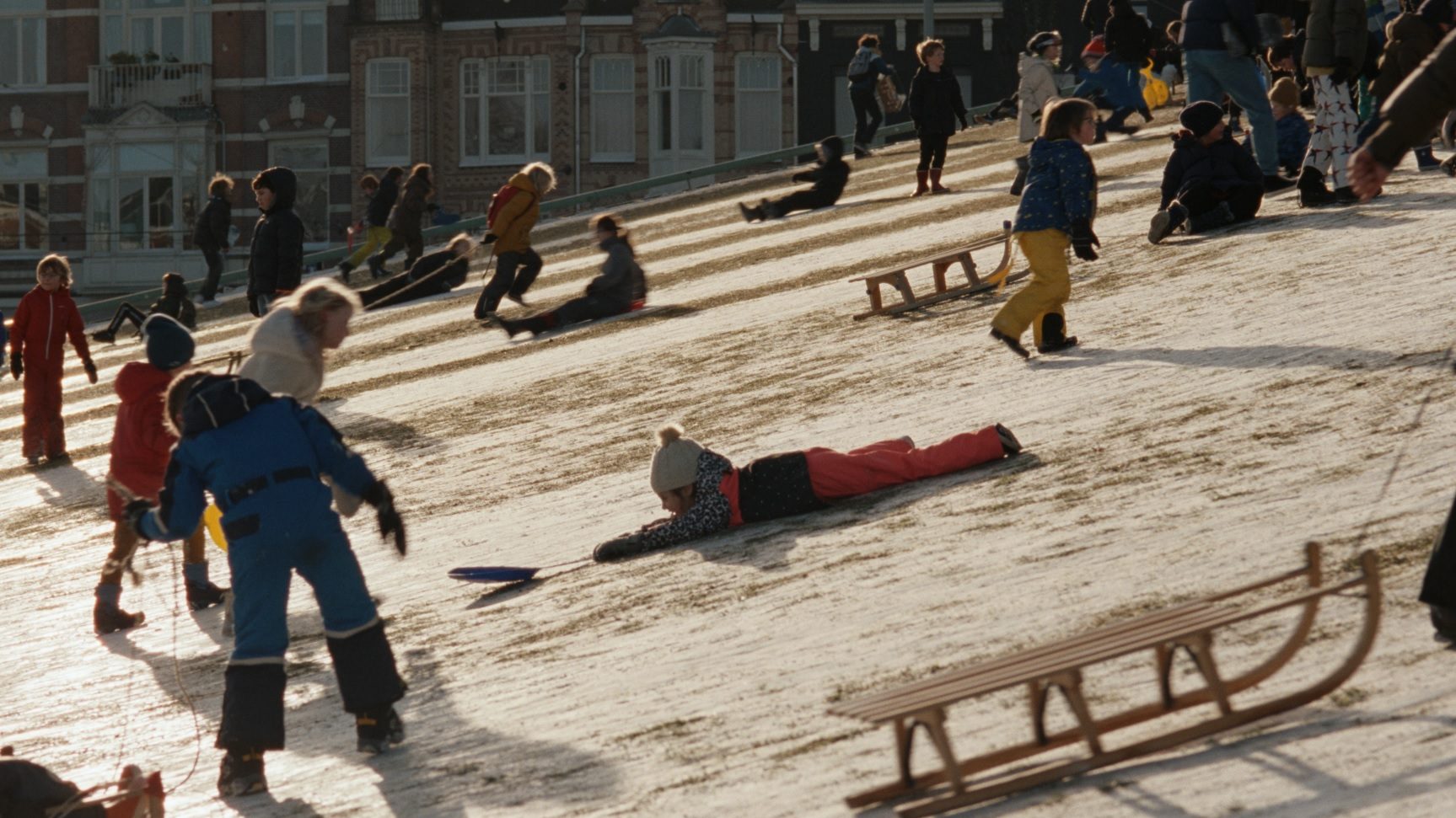 A scene from Steve McQueen’s Occupied City featuring carefree children sledging in Amsterdam, in stark contrast to the events that occurred in the city during the second world war. Photo: Family Affair Films & Lammas Park