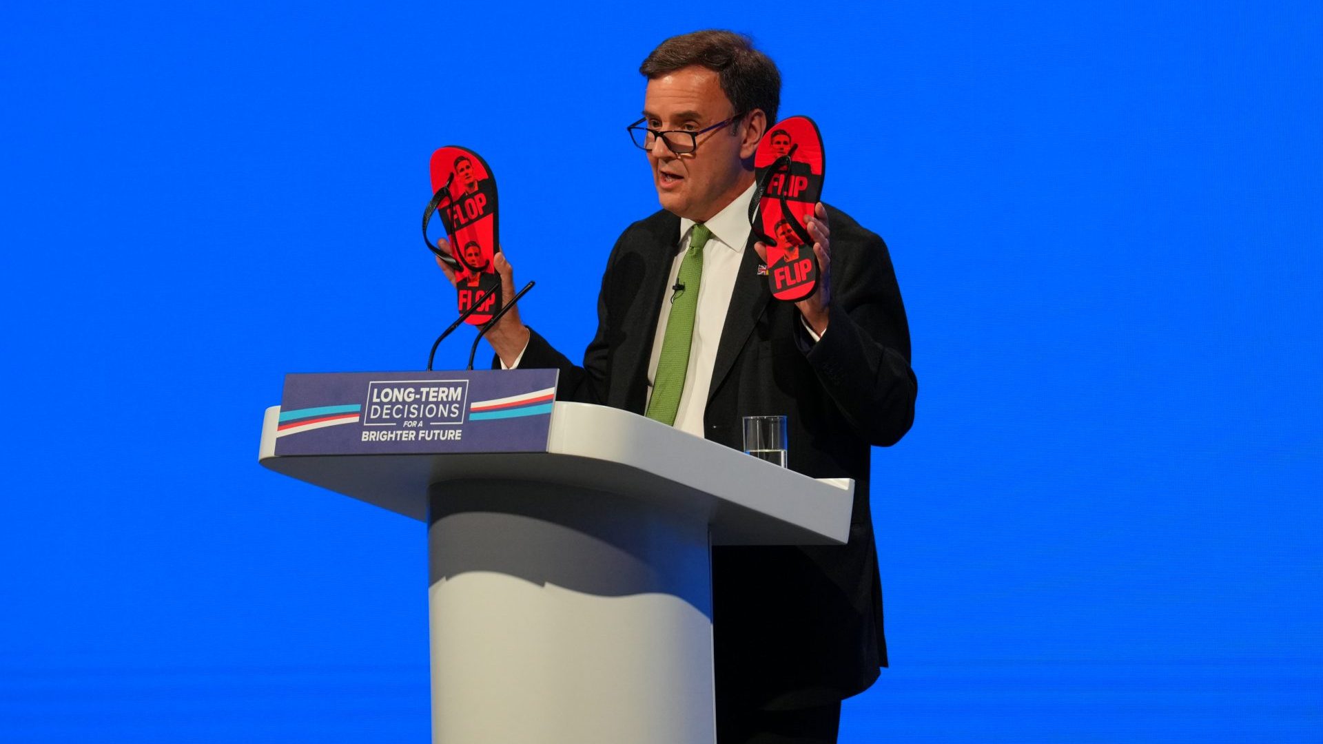 Greg Hands holds up some flip-flops with Keir Starmer on them at last year's Conservative Party Conference (Photo by Carl Court/Getty Images)
