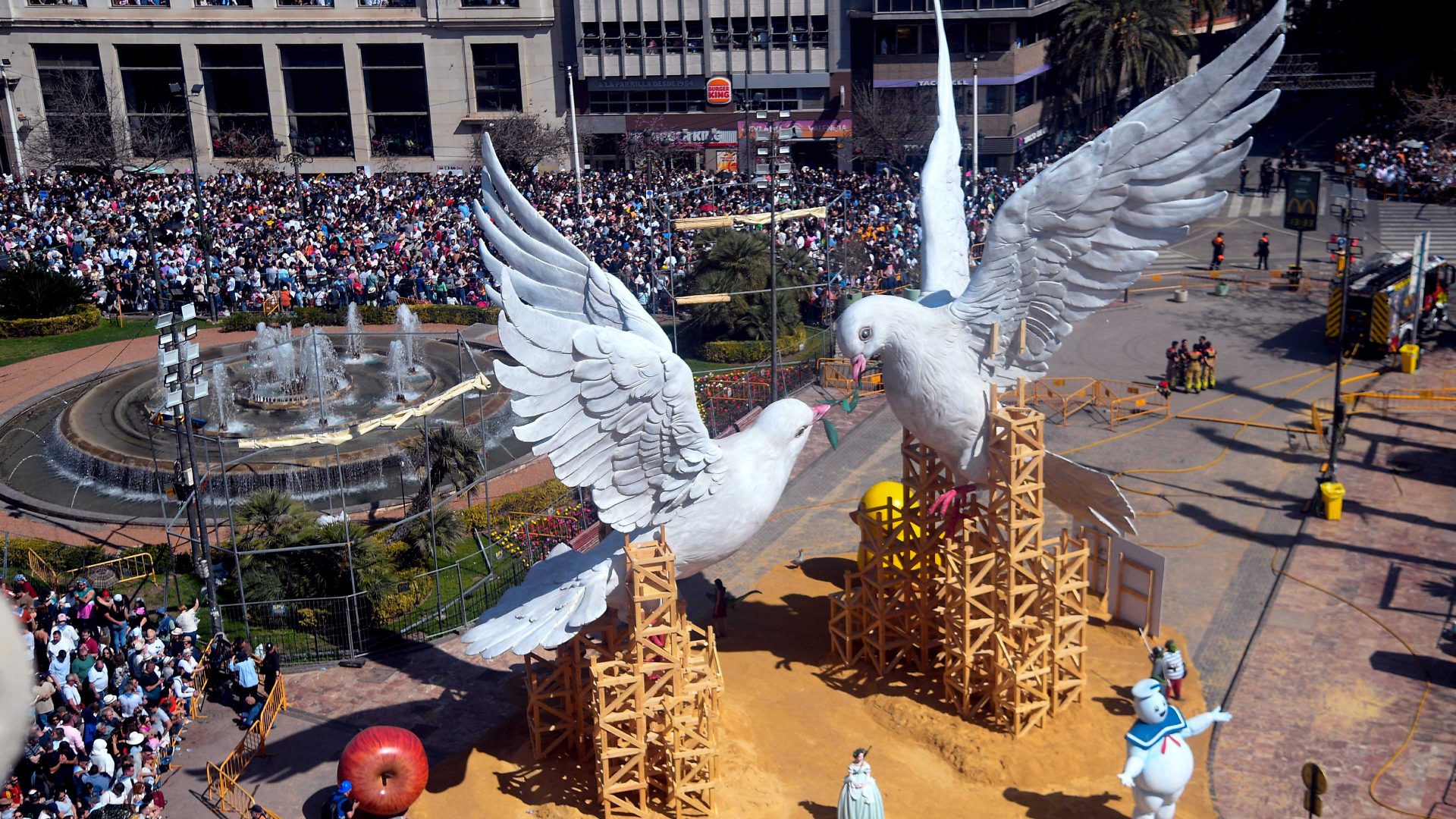 People gather around a falla to watch the traditional 'Mascleta' (firecrackers show) during the Fallas festival. Photo: JOSE JORDAN/STR/AFP via Getty Images