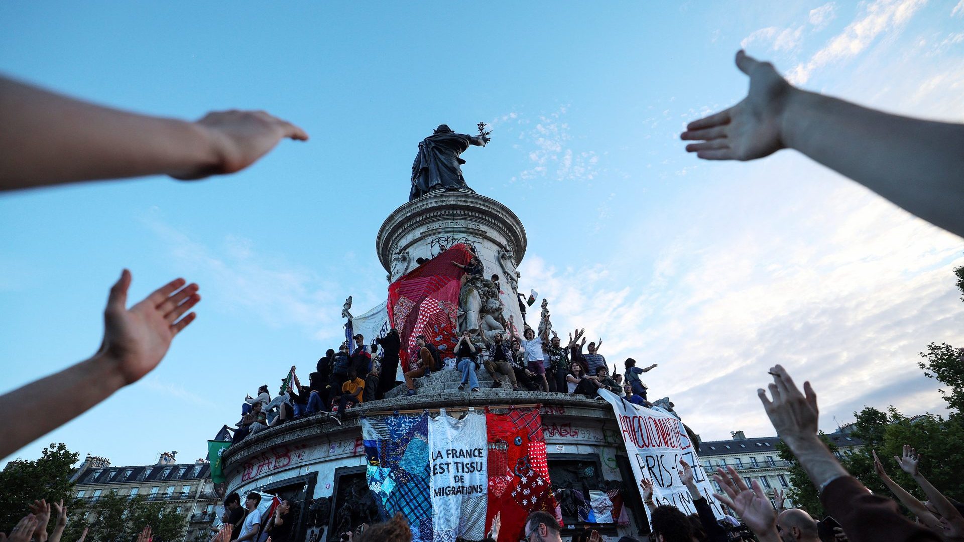 A giant banner
reads ‘France is the
fabric of migration’
during an election
night rally at Place
de la République in
Paris, July 7, 2024. Photo: Emmanuel
Dunand/AFP/Getty