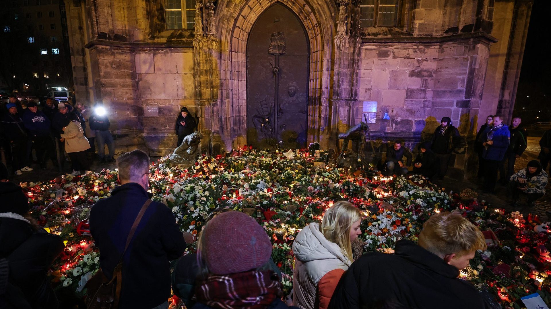 eople stand at a makeshift memorial near the site of a car-ramming attack on a Christmas market in Magdeburg. Photo: RONNY HARTMANN/AFP via Getty Images