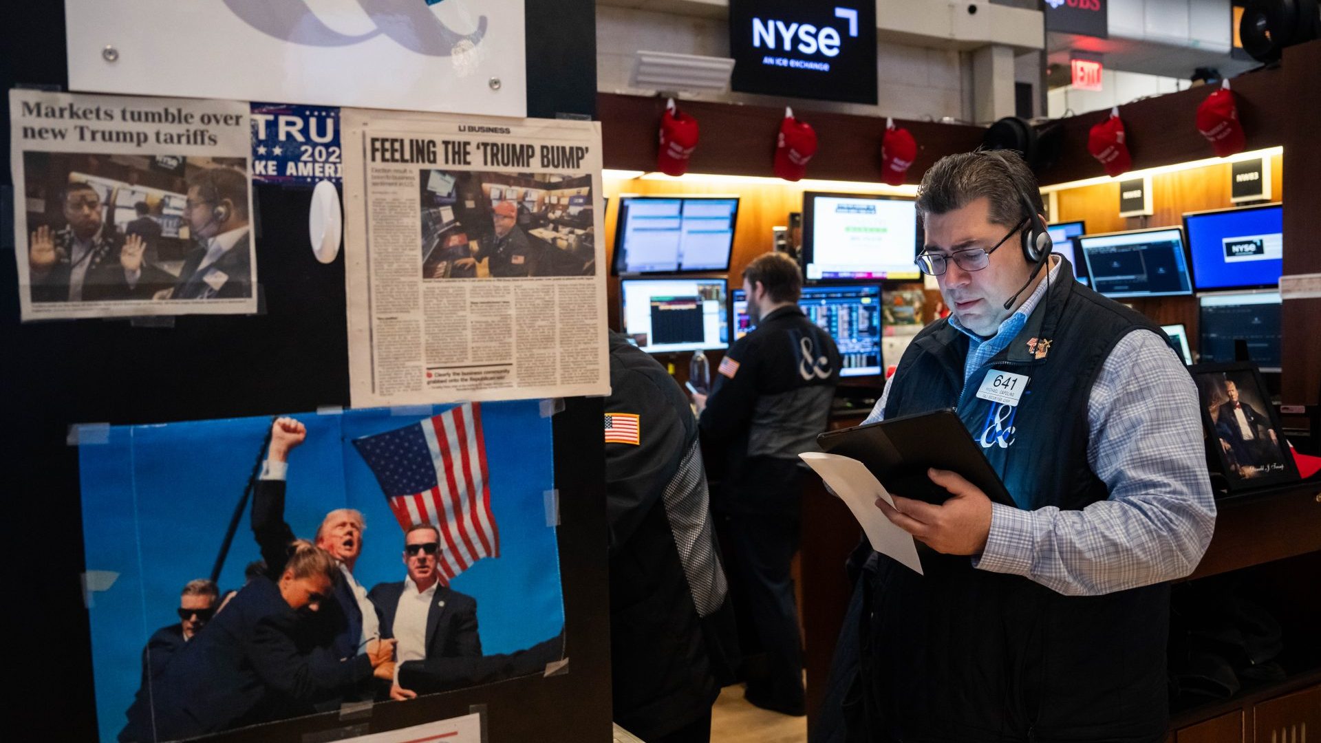 Traders work next to images of President Donald Trump on the floor of the New York Stock Exchange during morning trading. Photo: Adam Gray/Getty Images