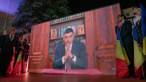 Presidential candidate George Simion is shown on a screen addressing his supporters at his campaign headquarters. Photo: Andrei Pungovschi/Getty Images